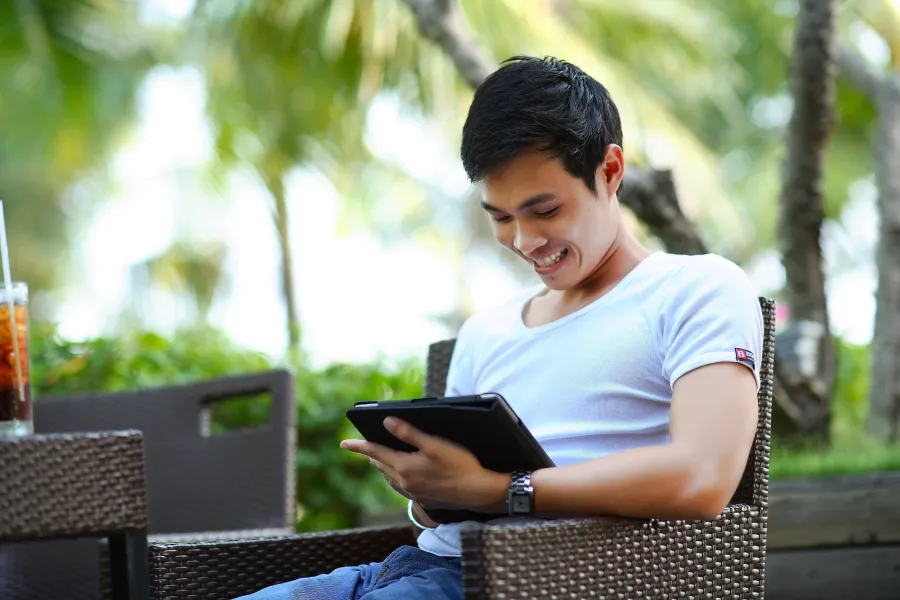 Man in white shirt holding a computer