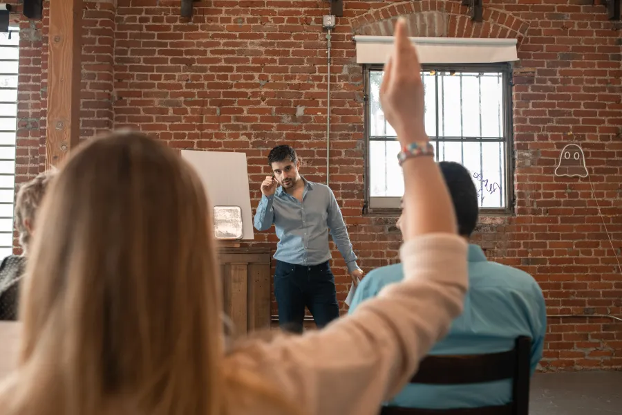 A bearded man pointing at participants